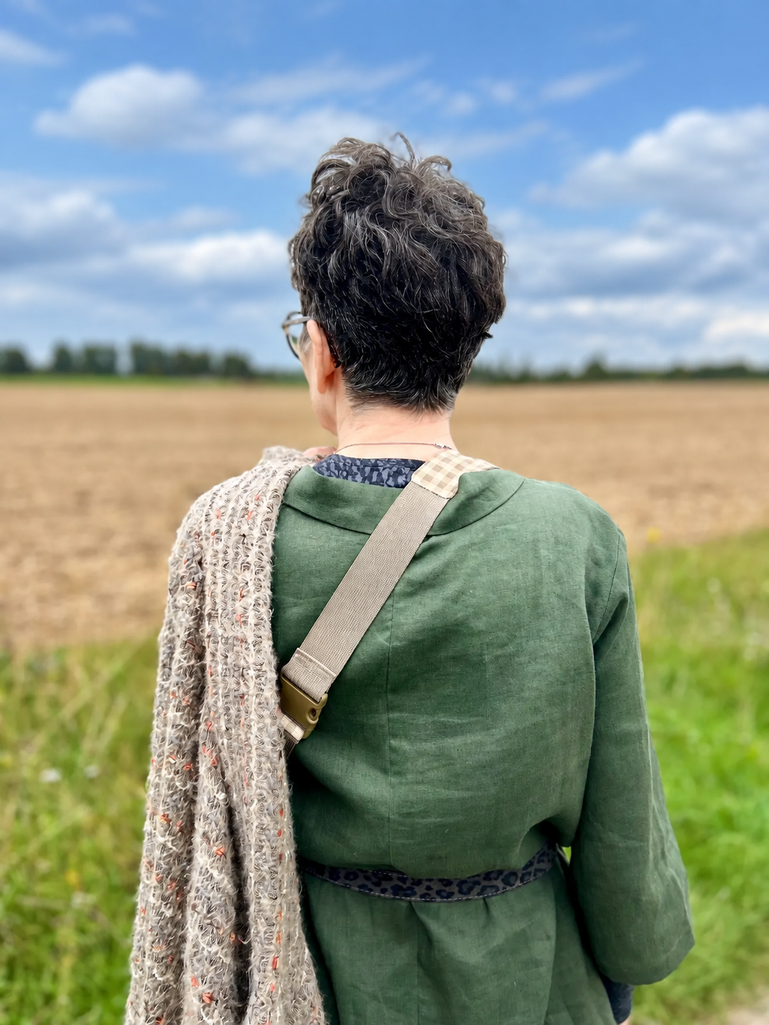 The back of Isobel’s olive green linen tunic, worn with a patterned belt and a knitted wrap
